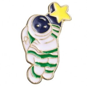 A whimsical enamel pin of a white astronaut with green stripes reaching up to grab a bright yellow five-pointed star.