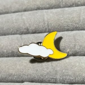 Crescent moon and cloud enamel pin with gold plating and vibrant yellow and white colors.