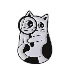 Whimsical black and white cat enamel pin holding a magnifying glass over its eye with polished silver-toned plating.