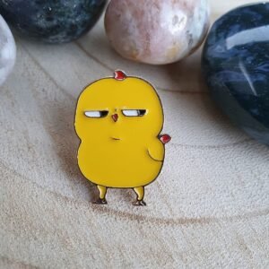 Sassy yellow chick enamel pin with a grumpy expression and a tiny red heart detail.