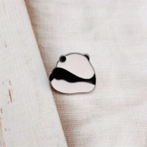 A minimalist, round black and white panda bear enamel pin with silver-toned plating.
