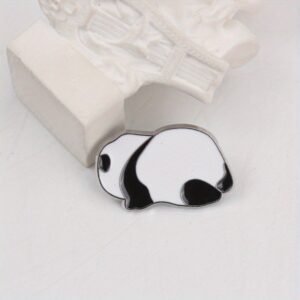 A minimalist silver-plated enamel pin of a panda bear sleeping on its belly.