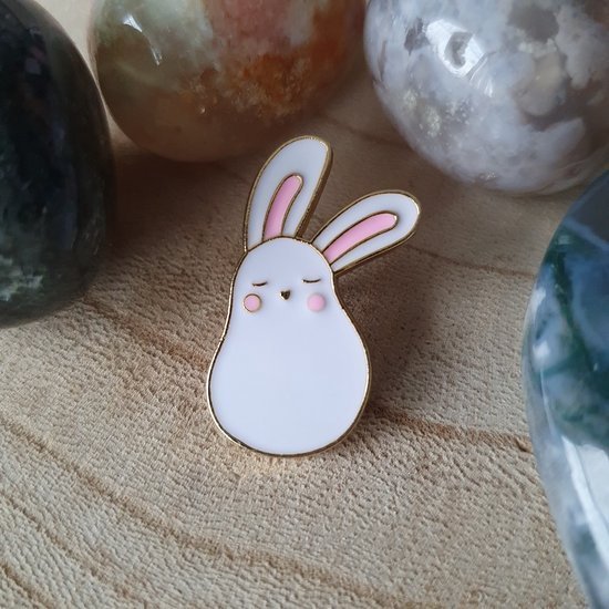 A white pear-shaped bunny enamel pin with pink ears and cheeks, shown with closed, sleepy eyes.