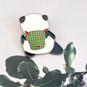 A back-view enamel pin of a panda bear carrying a green woven basket or backpack with red straps.