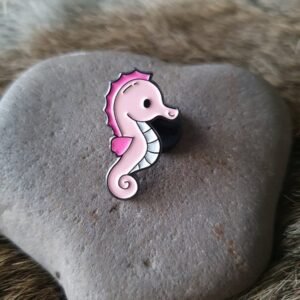 Pink seahorse enamel pin featuring a cute cartoon design with hot pink accents and a white belly.