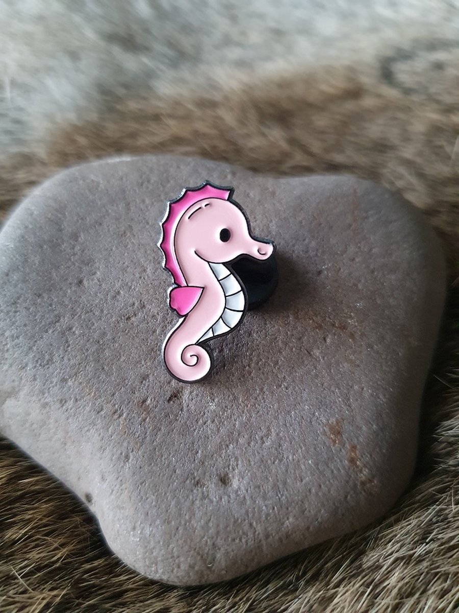 Pink seahorse enamel pin featuring a cute cartoon design with hot pink accents and a white belly.