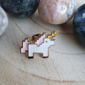Retro pixel art unicorn enamel pin in pastel pink and white with a yellow lightning bolt horn and gold trim.