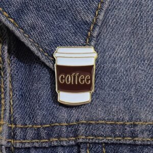 White and brown takeout coffee cup enamel pin with the word coffee written on the sleeve.