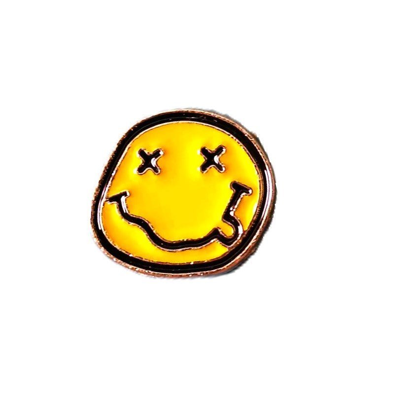 Yellow smiley face enamel pin with "X" eyes and a melting aesthetic, inspired by 90s grunge culture.
