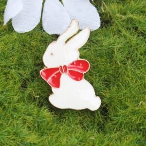 Elegant white rabbit enamel pin wearing a vibrant red bow tie with jewelry-grade gold plating.