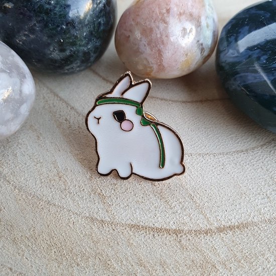 White bunny enamel pin featuring a warrior-style green headband.