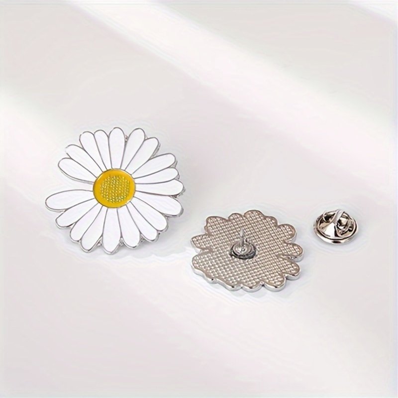 Front and back view of a white daisy flower pin showing the secure silver-toned butterfly clutch.
