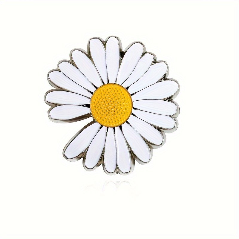 White daisy flower pin pinned to the lapel of a classic blue denim jacket.