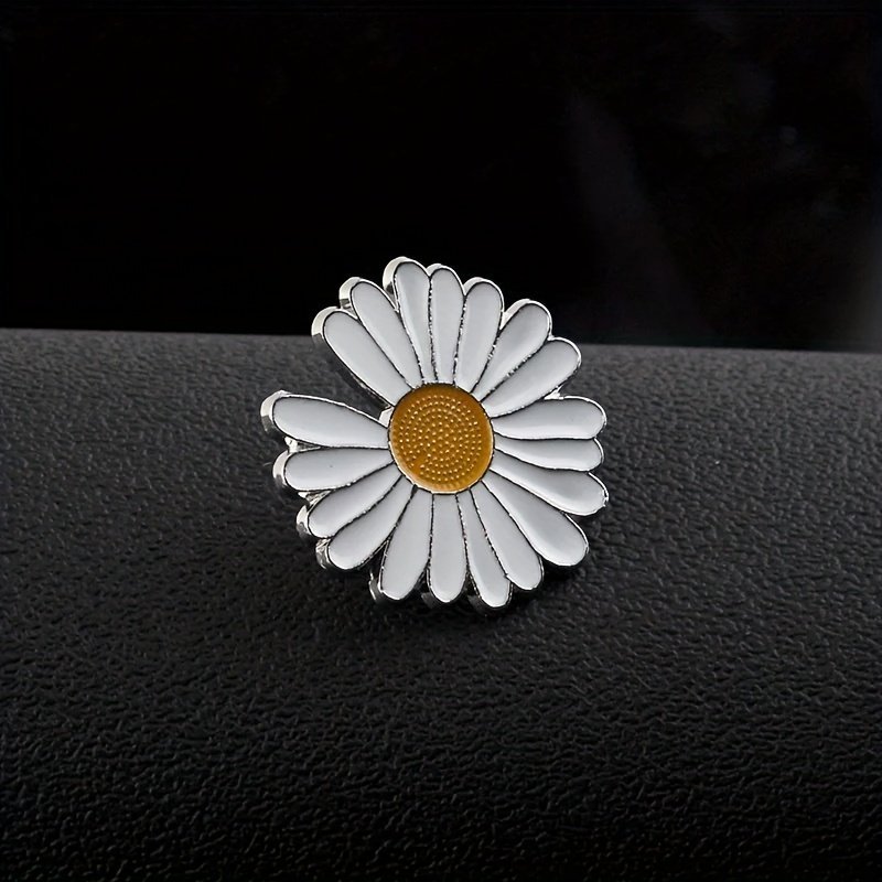 White daisy flower pin with vibrant yellow center and silver metal detailing.