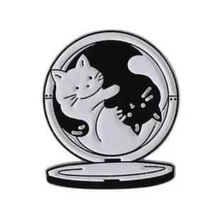 Black and white cats forming a yin-yang symbol inside a circular compact mirror enamel pin design.