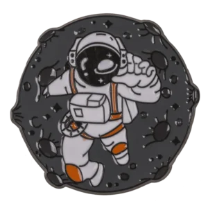 Astronaut space badge – cosmonaut in white spacesuit with orange details floating among dark asteroids hard enamel pin gunmetal base