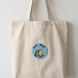 Don't Worry Bee Happy patch on a canvas tote bag
