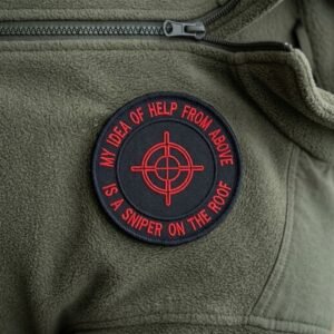 Sniper on the roof patch with a red crosshair on an olive green fleece jacket